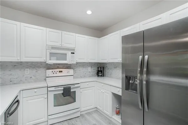 a kitchen with appliances a sink and cabinets