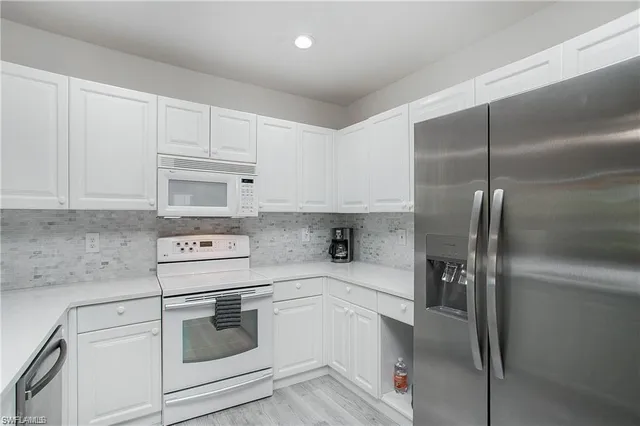 a kitchen with appliances a sink and cabinets