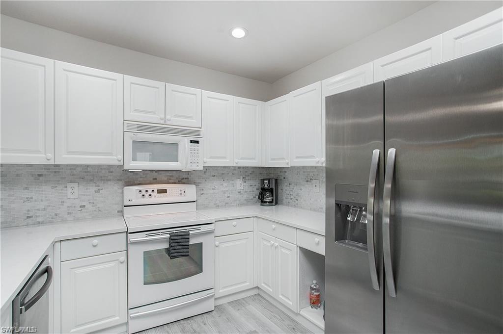 700 Diamond Circle, Unit 706 Naples, FL 34110 - Photo 11 of 37 a kitchen with appliances a sink and cabinets