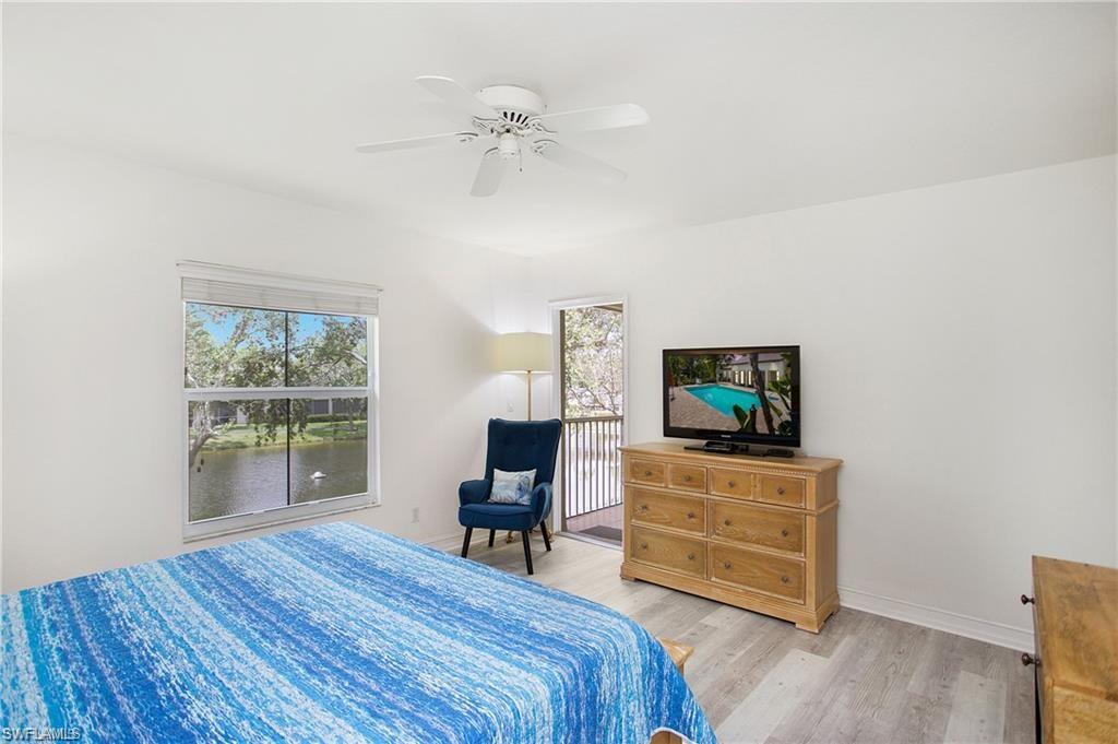 700 Diamond Circle, Unit 706 Naples, FL 34110 - Photo 23 of 37 a bedroom with furniture and a flat screen tv
