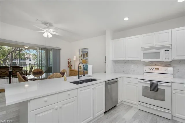 a kitchen with white cabinets and white appliances