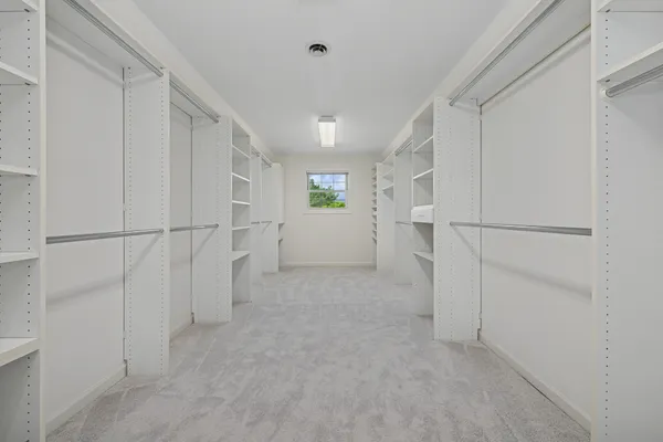 a view of storage and utility room with refrigerator and white walls