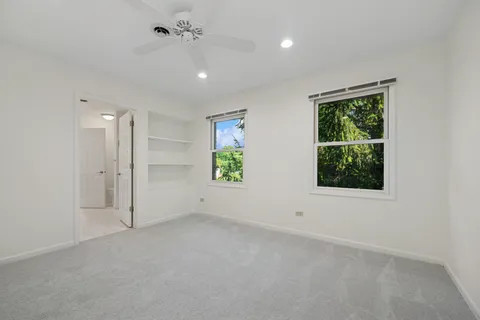 an empty room with a window and a ceiling fan
