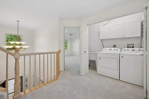 a utility room with cabinets washer and dryer