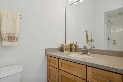 a bathroom with a granite countertop sink a toilet and a mirror