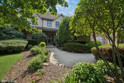a front view of a house with a yard and a garden