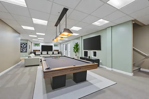 a kitchen with stainless steel appliances kitchen island a sink and a television