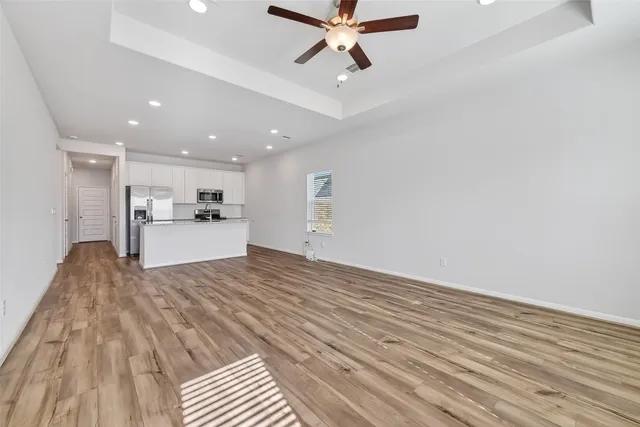 a view of a kitchen with a sink and dishwasher with wooden floor
