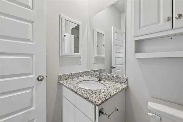 a bathroom with a granite countertop sink and a mirror