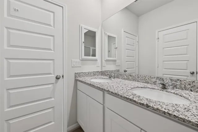 a bathroom with a granite countertop sink and a mirror
