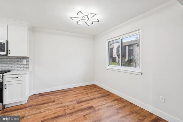 a view of empty room with a fireplace and wooden floor