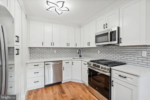 a kitchen with cabinets stainless steel appliances and a sink