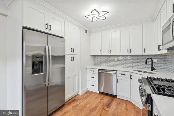 a kitchen with stainless steel appliances granite countertop a stove a sink and a refrigerator