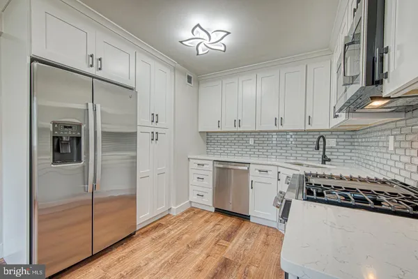 a kitchen with granite countertop a refrigerator and a stove top oven