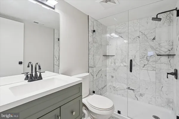 a bathroom with a sink toilet vanity and shower