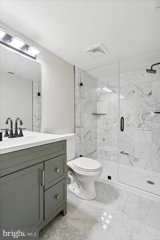 a bathroom with a double vanity sink toilet and shower