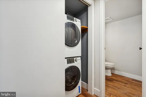 a walk in closet with wooden floor