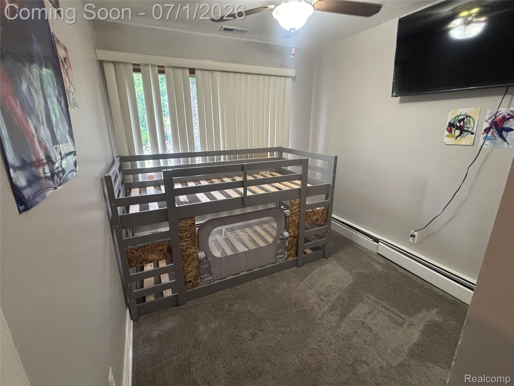9844 Pine Knob Road Clarkston, MI 48348 - Photo 10 of 15 Carpeted room featuring vertical blinds, a ceiling fan with integrated lighting, and baseboard heating