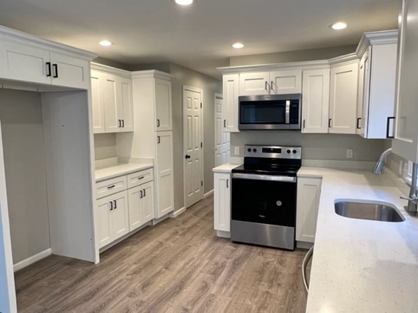 5 Winesap Way Ashland, MA 01721 - Photo 5 of 22 a kitchen with stainless steel appliances a stove sink microwave and cabinets