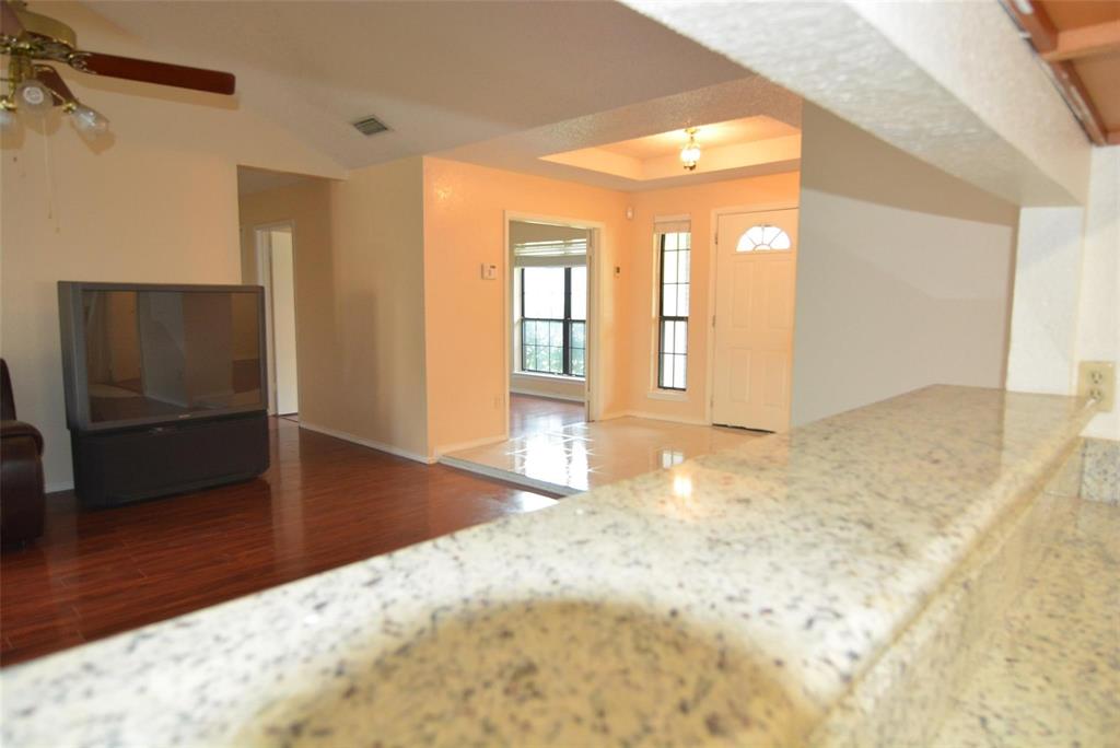 210 Apollo Road Garland, TX 75040 - Photo 12 of 27 a view of a hallway with wooden floor and a living room