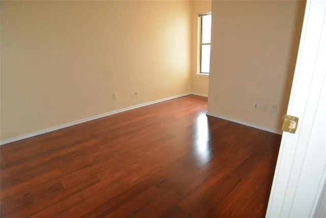 a view of a hallway with wooden floor and a chandelier