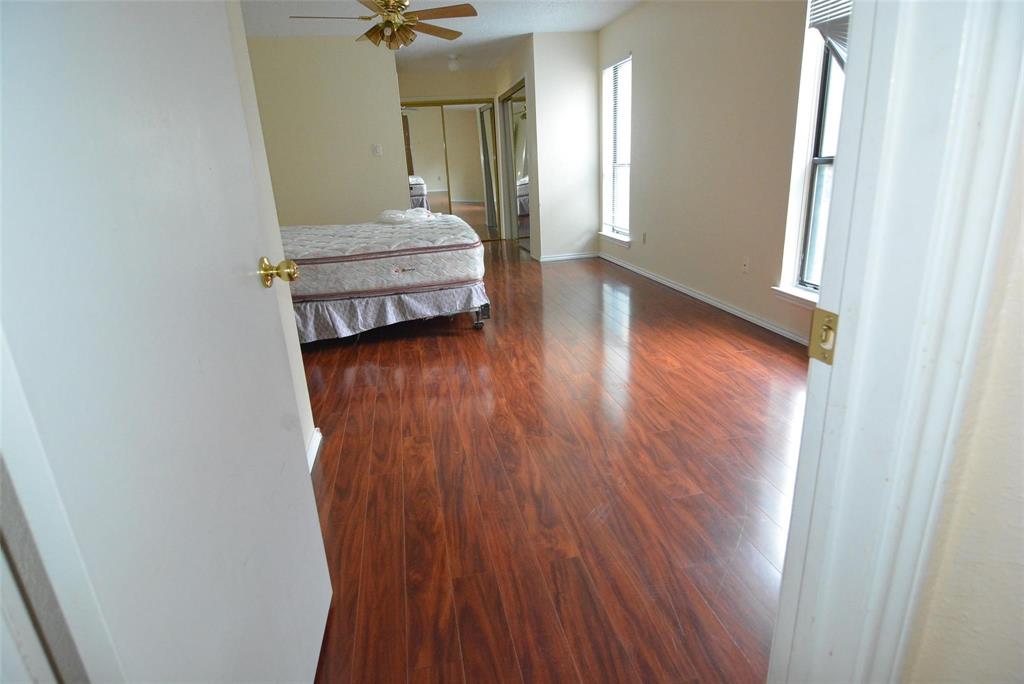 210 Apollo Road Garland, TX 75040 - Photo 17 of 27 a view of a hallway with wooden floor and a chandelier