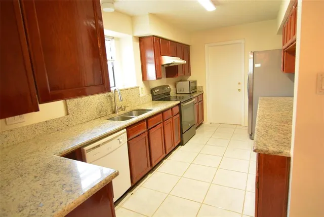 a kitchen with stainless steel appliances kitchen island granite countertop a sink and cabinets