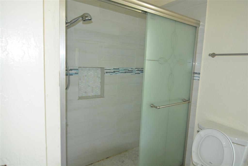 210 Apollo Road Garland, TX 75040 - Photo 24 of 27 a bathroom with a granite countertop toilet and a shower