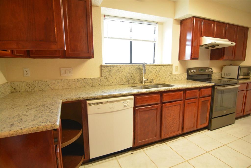 210 Apollo Road Garland, TX 75040 - Photo 3 of 27 a kitchen with stainless steel appliances granite countertop a sink stove and cabinets