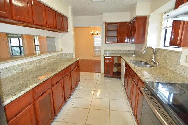 a large kitchen with kitchen island granite countertop a sink and cabinets