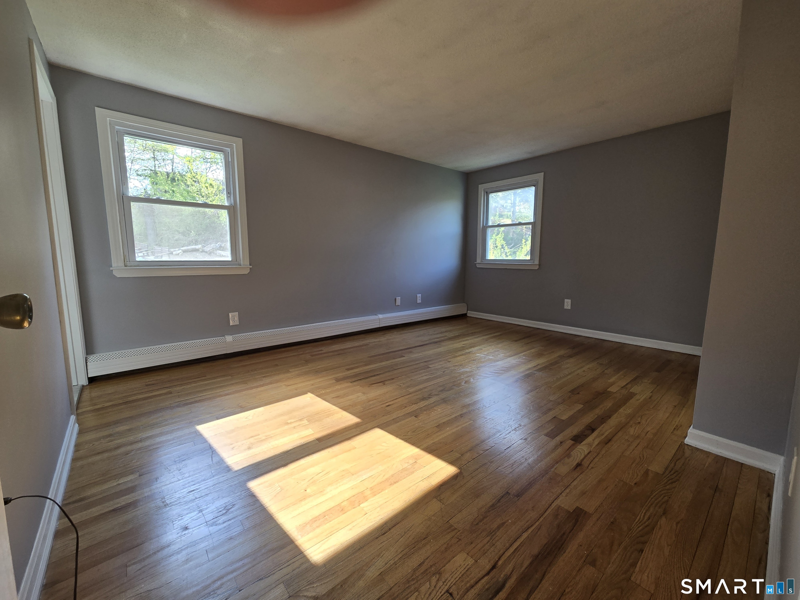 1004 Hickory Hill Road Thomaston, CT 06787 - Photo 21 of 23 an empty room with wooden floor and windows