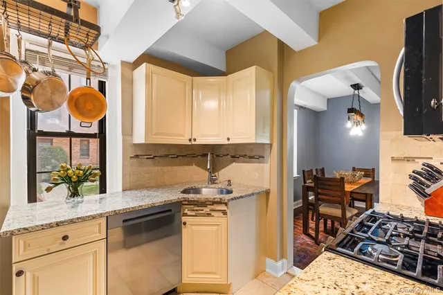a kitchen with stainless steel appliances a stove a sink and a wooden cabinets