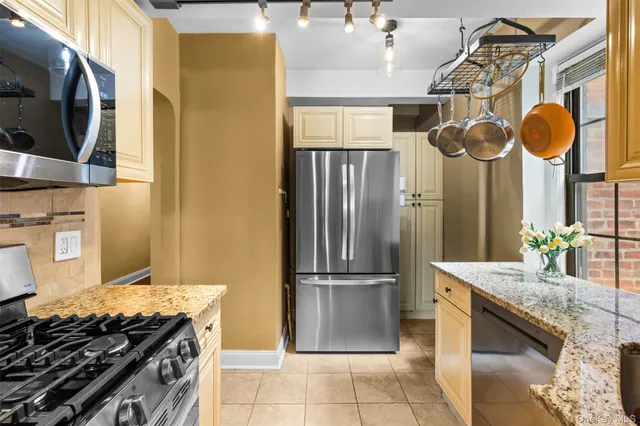 a kitchen with stainless steel appliances granite countertop a stove and a refrigerator