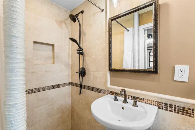 a bathroom with a sink a mirror and a shower