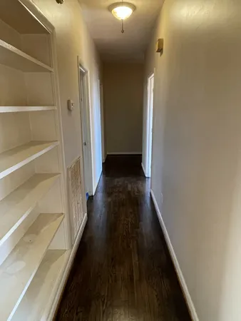 a view of a hallway with wooden floor and stairs