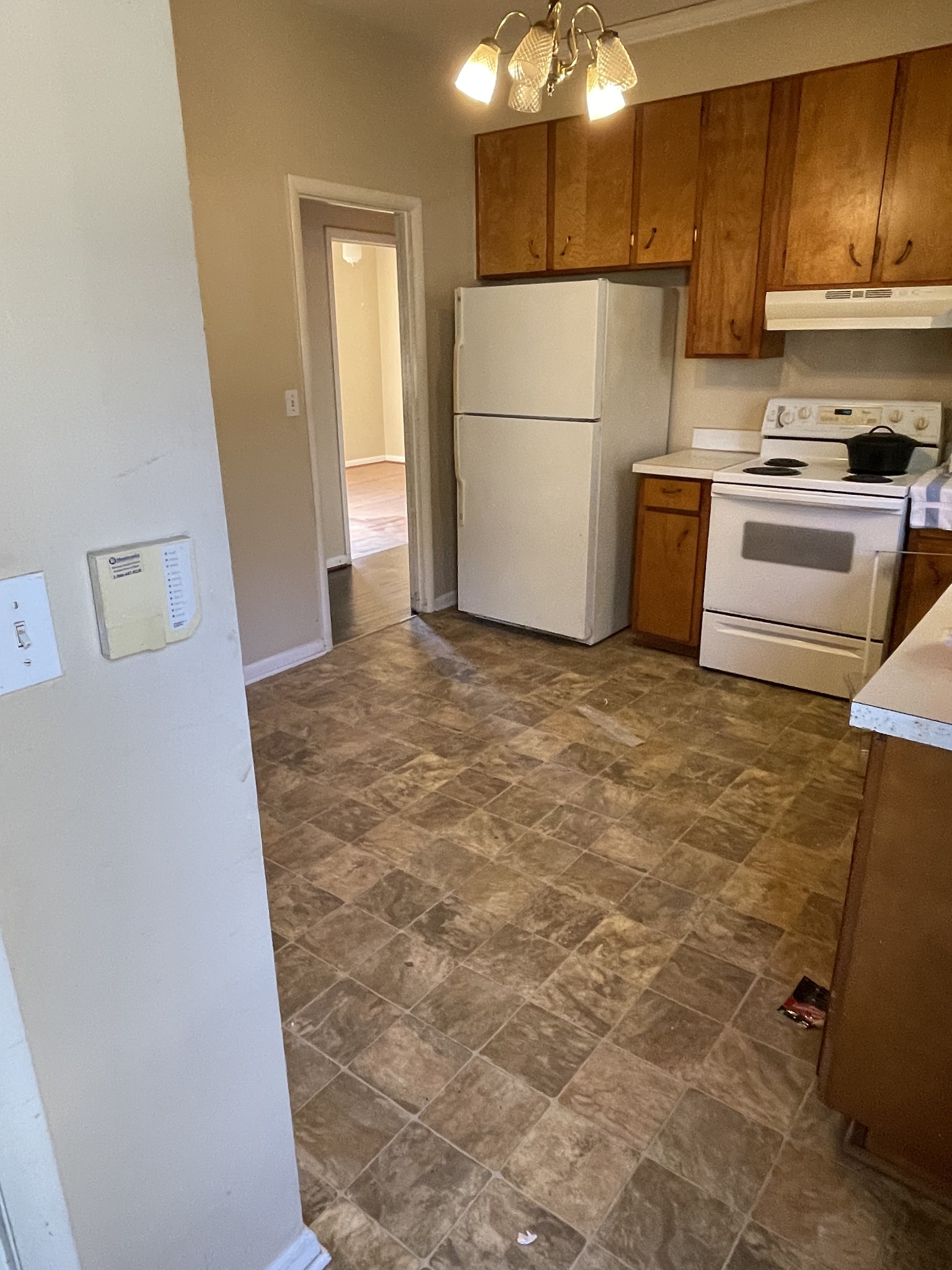550 East Jefferson Street Pulaski, TN 38478 - Photo 9 of 23 a view of a refrigerator in kitchen and an empty room with wooden floor