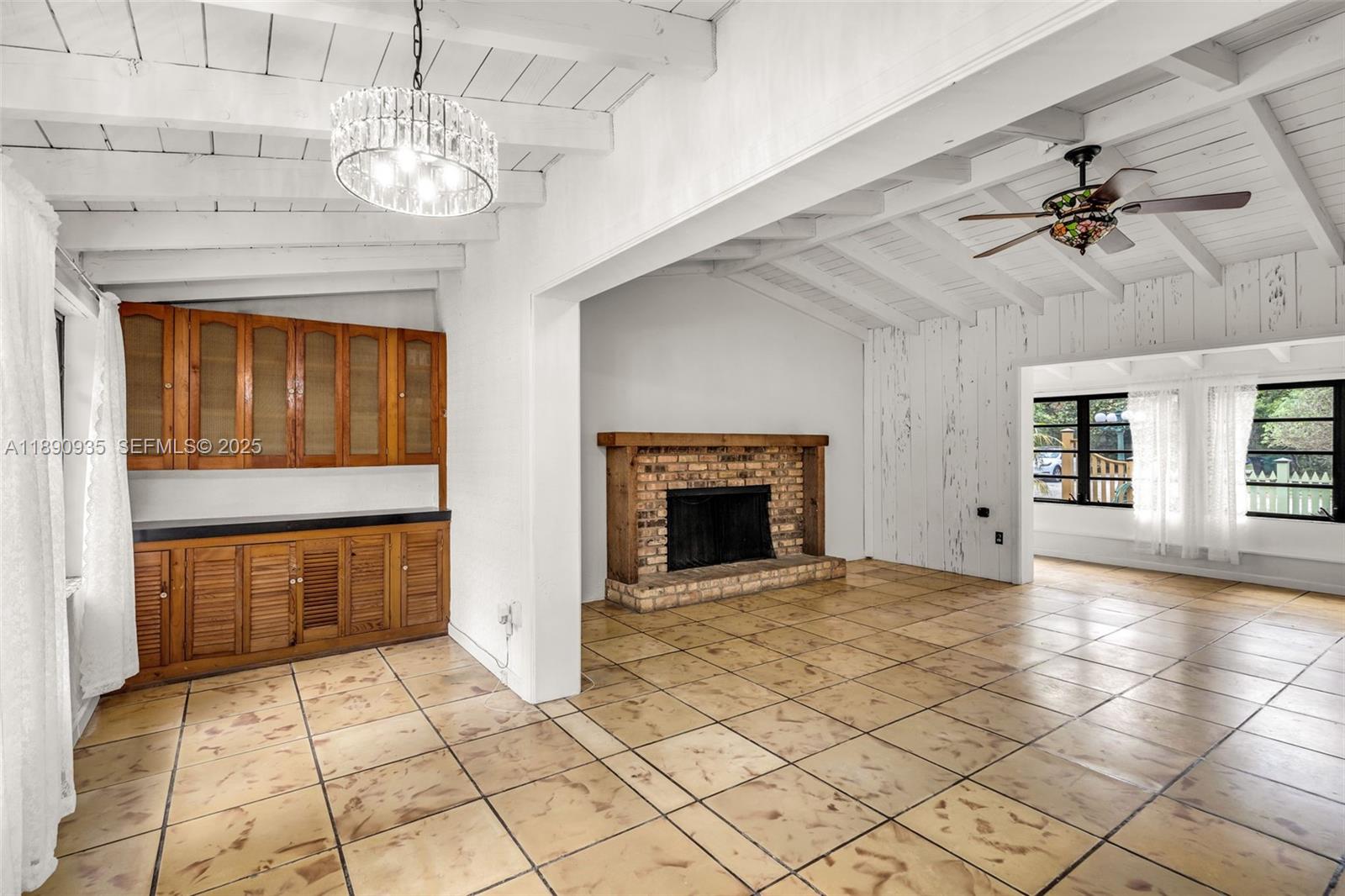 6031 Southwest 82nd Avenue Miami, FL 33143 - Photo 11 of 42 a view of an empty room with a fireplace and a chandelier fan