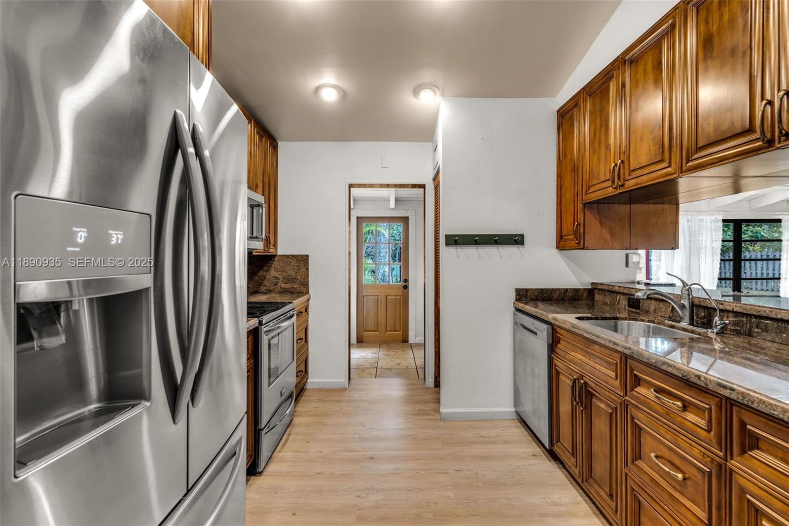 6031 Southwest 82nd Avenue Miami, FL 33143 - Photo 15 of 42 a kitchen with stainless steel appliances granite countertop a refrigerator a stove and a sink