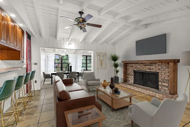 a view of an empty room with a fireplace and a chandelier fan