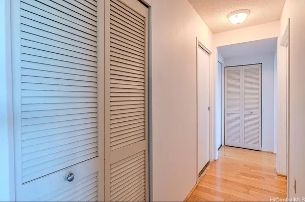 a view of a hallway with closet and bathroom