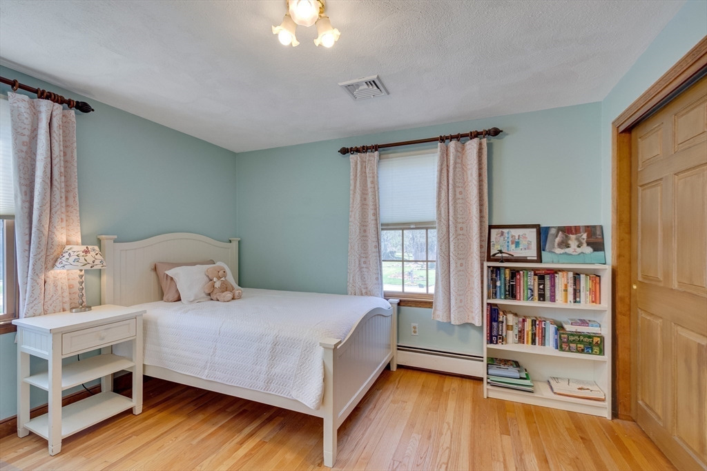 6 Apollo Circle Lexington, MA 02421 - Photo 19 of 38 a bedroom with a bed and a book shelf