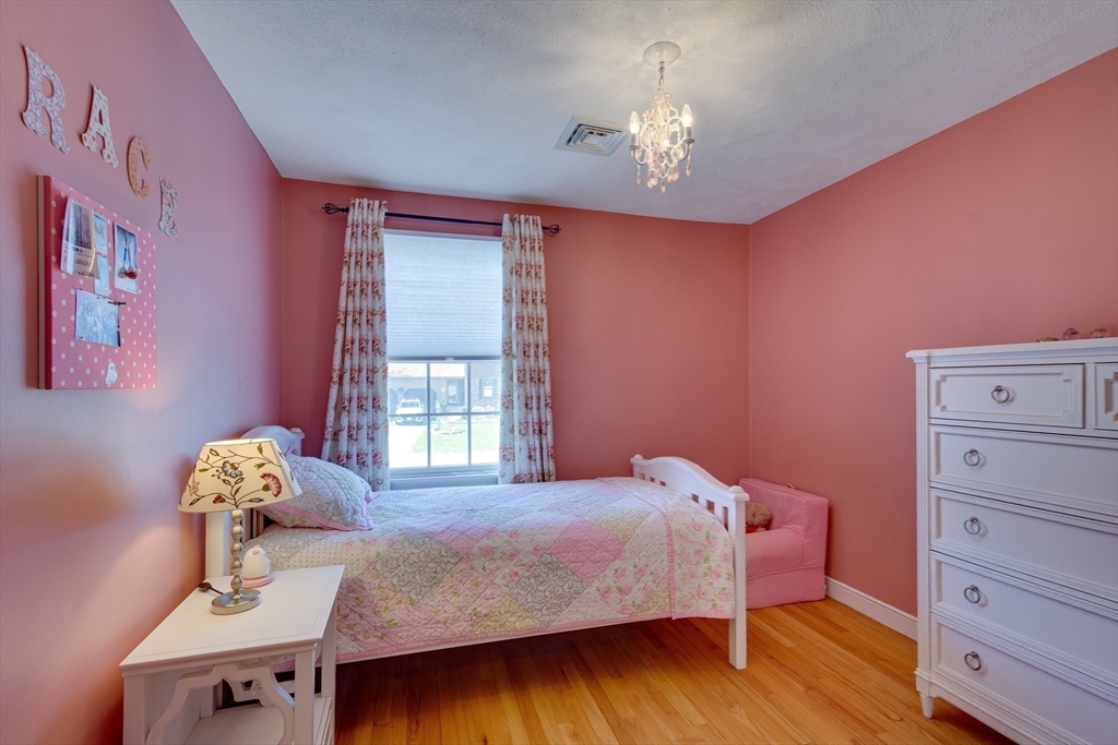 6 Apollo Circle Lexington, MA 02421 - Photo 22 of 38 a bedroom with a bed and chandelier