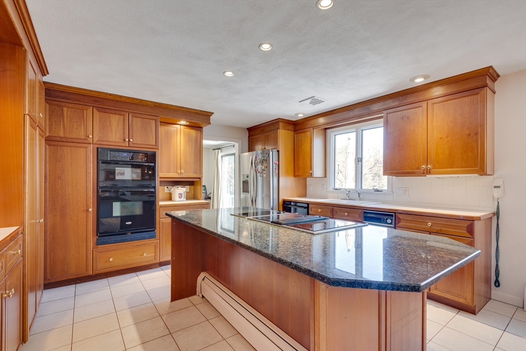 6 Apollo Circle Lexington, MA 02421 - Photo 5 of 38 a kitchen with stainless steel appliances granite countertop a sink a stove and a refrigerator