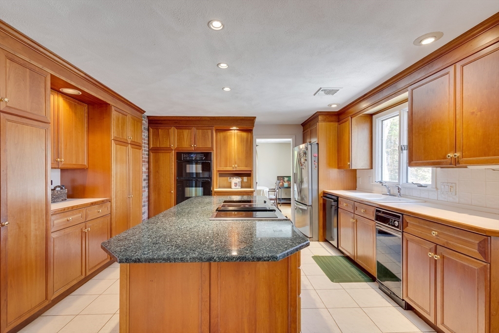 6 Apollo Circle Lexington, MA 02421 - Photo 6 of 38 a kitchen with stainless steel appliances granite countertop a sink dishwasher stove and refrigerator with wooden floor
