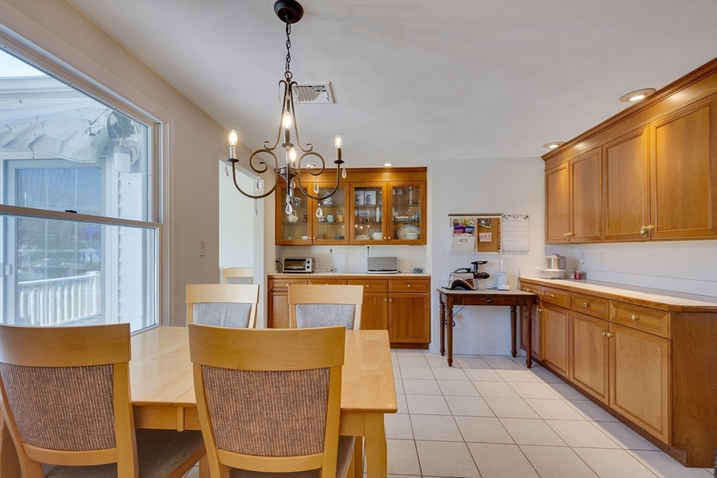 6 Apollo Circle Lexington, MA 02421 - Photo 8 of 38 a large kitchen with stainless steel appliances kitchen island granite countertop a table and chairs in it