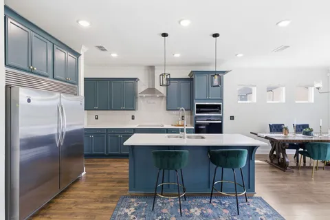a kitchen with stainless steel appliances granite countertop a sink refrigerator and cabinets