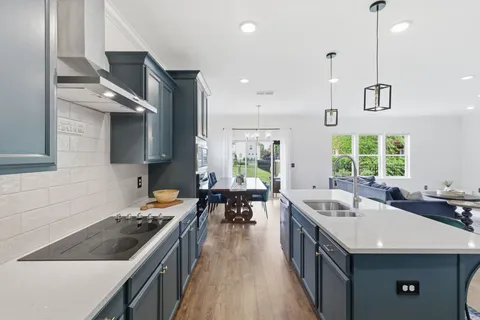 a kitchen with sink stove and chairs