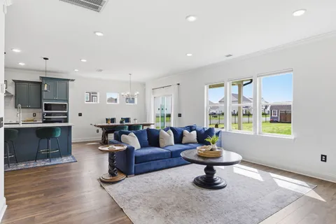 a living room with furniture and a dining table with kitchen view