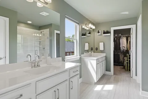 a bathroom with a double vanity sink toilet mirror and shower