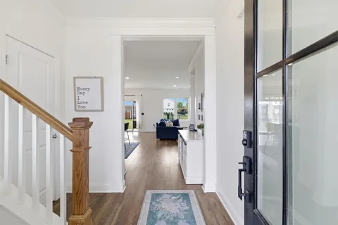 a view of a hallway view with living room and wooden floor
